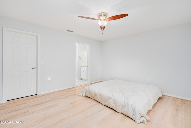 bedroom featuring connected bathroom, ceiling fan, and light hardwood / wood-style flooring