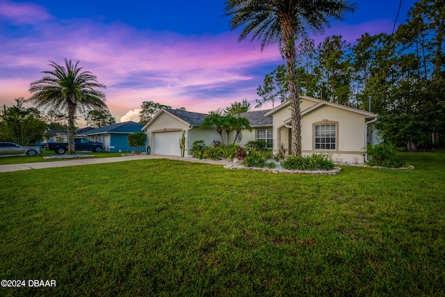 ranch-style home with a garage and a yard