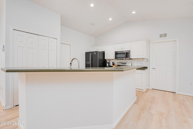 kitchen with stainless steel appliances, a center island with sink, and white cabinets