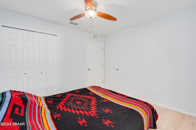 bedroom with ceiling fan, a closet, and light hardwood / wood-style flooring