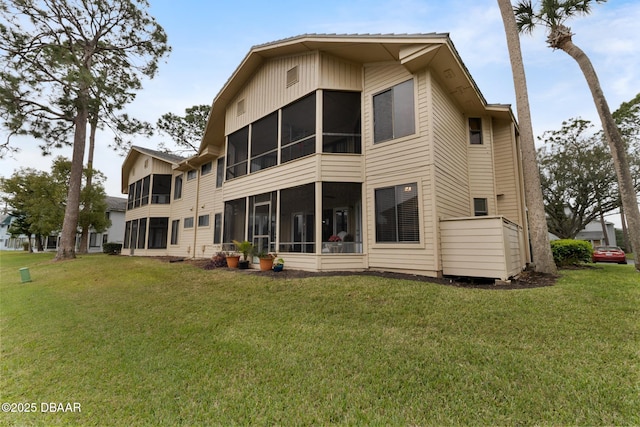 back of property with a sunroom and a yard