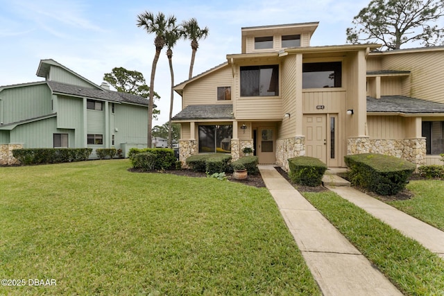 townhome / multi-family property featuring stone siding and a front lawn