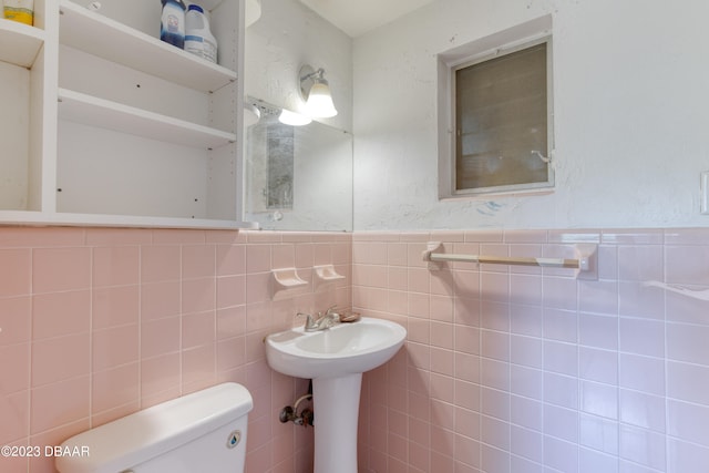 bathroom with toilet and tile walls