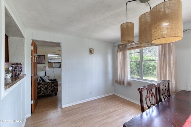 dining room with hardwood / wood-style floors and wood walls