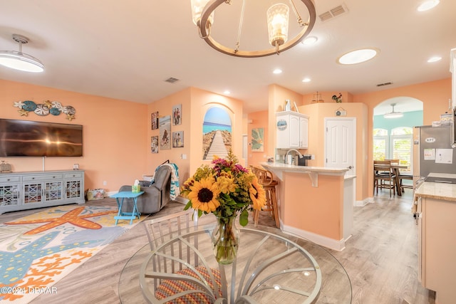 dining area featuring light hardwood / wood-style floors, an inviting chandelier, and sink