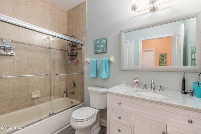 full bathroom with toilet, combined bath / shower with glass door, and vanity