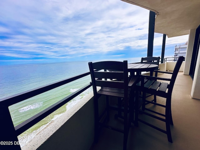 balcony featuring a water view and a view of the beach