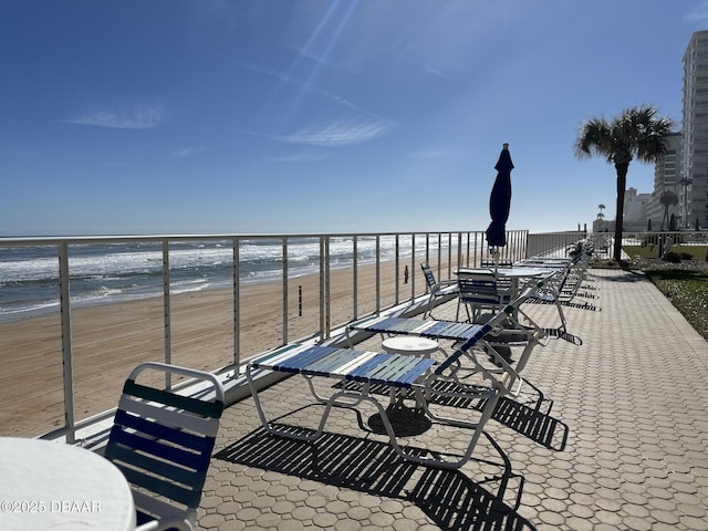 view of patio with a beach view and a water view