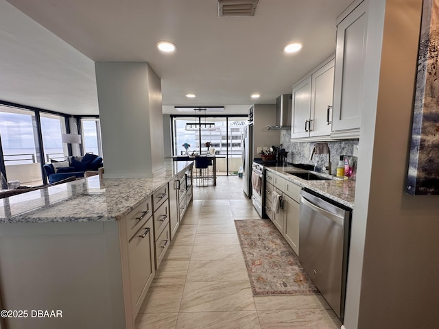 kitchen featuring light stone counters, sink, decorative backsplash, and appliances with stainless steel finishes