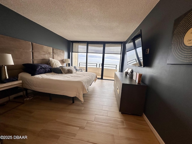 bedroom with access to exterior and a textured ceiling