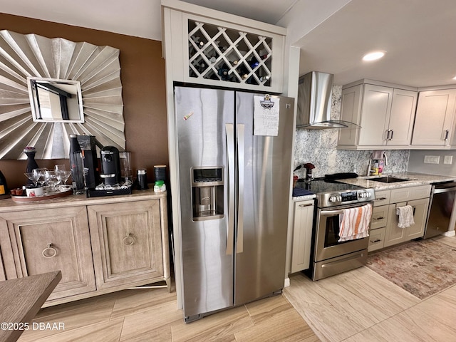 kitchen featuring wall chimney exhaust hood, sink, and stainless steel appliances