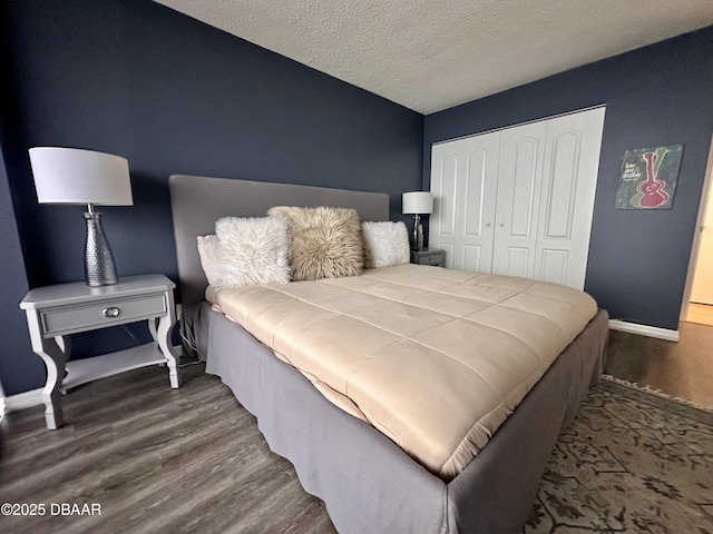 bedroom featuring a closet, dark wood-type flooring, and a textured ceiling