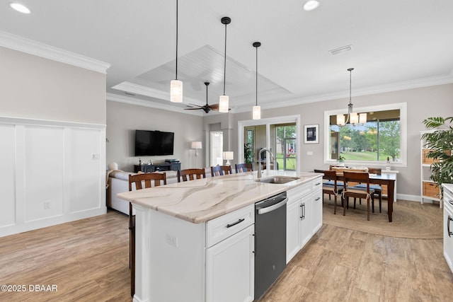 kitchen with a sink, ornamental molding, light wood-style flooring, and dishwasher