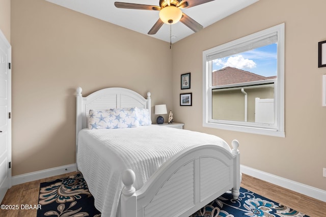 bedroom featuring baseboards, a ceiling fan, and wood finished floors