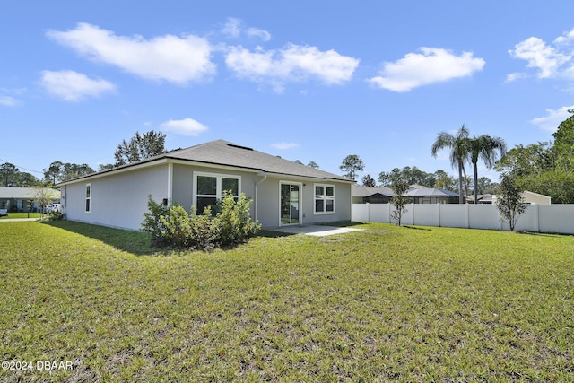 back of property with a patio area and a lawn