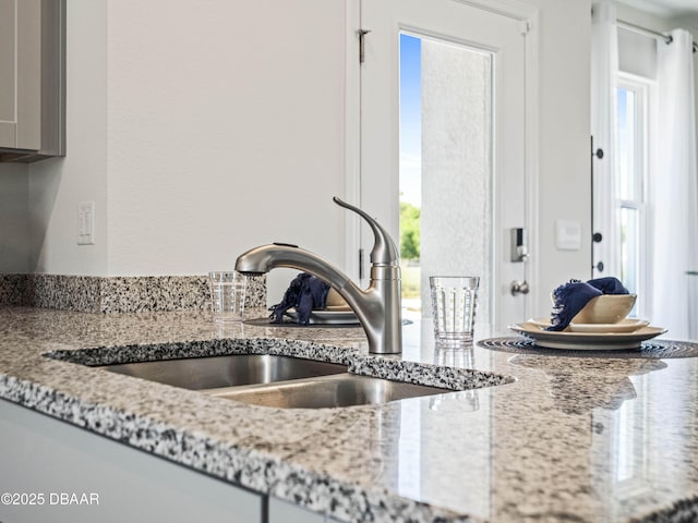 kitchen with sink and light stone countertops