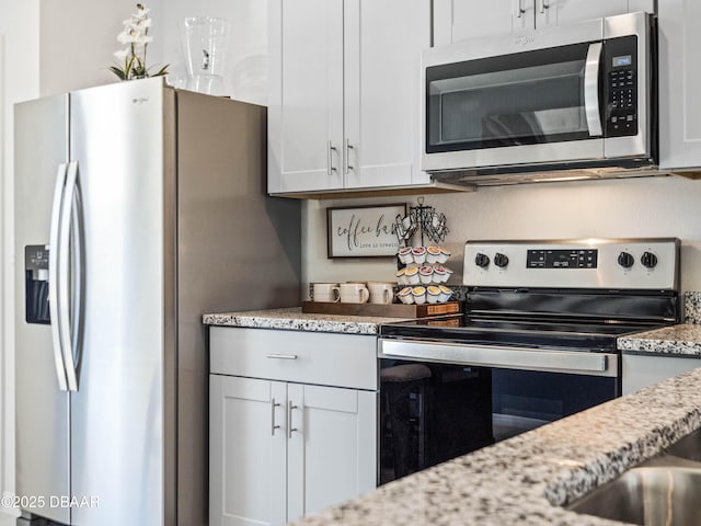 kitchen featuring light stone countertops, white cabinets, and appliances with stainless steel finishes