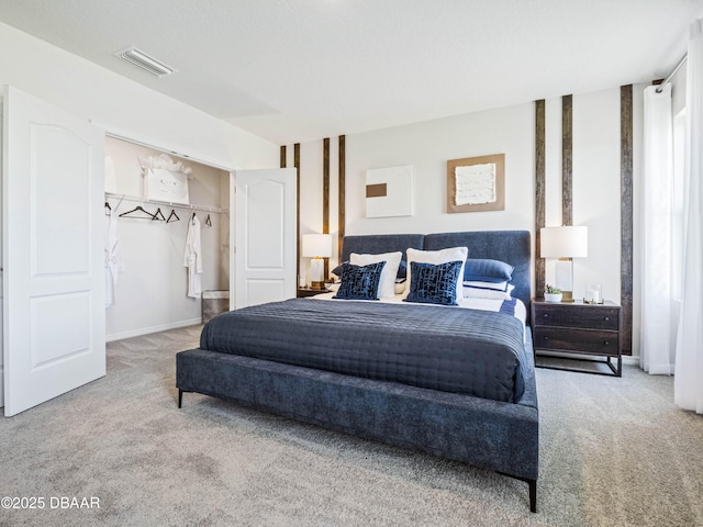 carpeted bedroom featuring a walk in closet