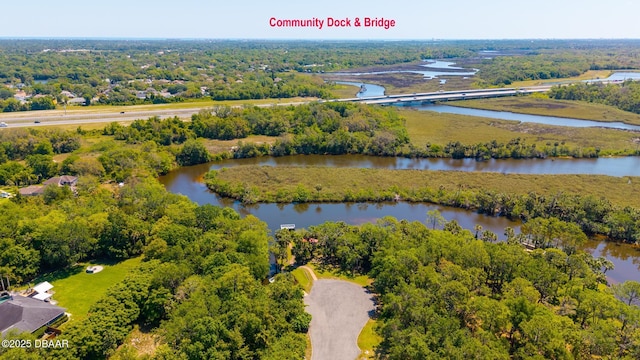 aerial view with a water view and a forest view