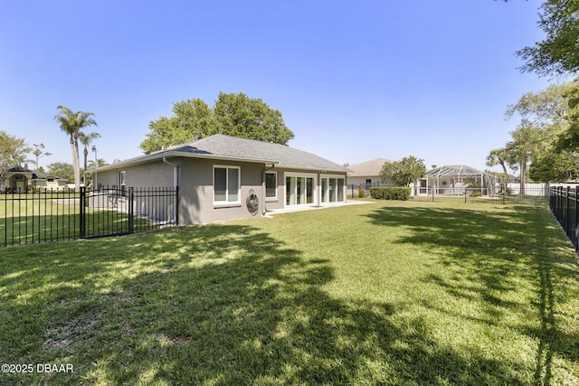 back of house featuring a fenced backyard, stucco siding, and a lawn