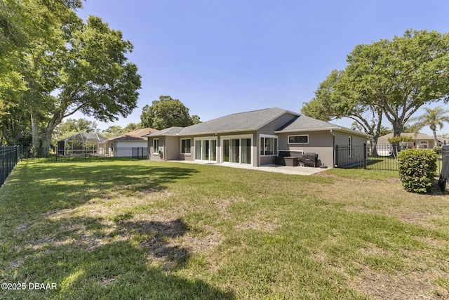 rear view of house with a yard, a fenced backyard, a patio, and stucco siding