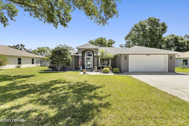 ranch-style house with an attached garage, driveway, a front yard, and stucco siding