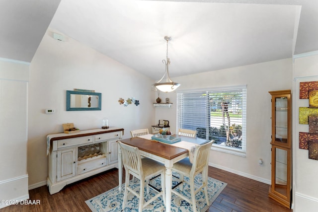 dining room with dark wood-style flooring, baseboards, and vaulted ceiling
