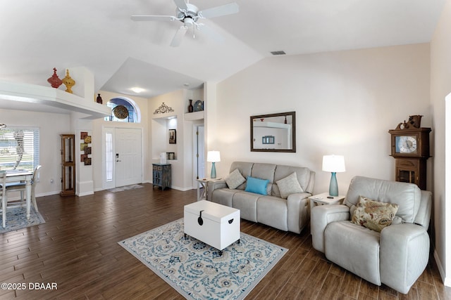 living area with visible vents, a ceiling fan, vaulted ceiling, and dark wood finished floors