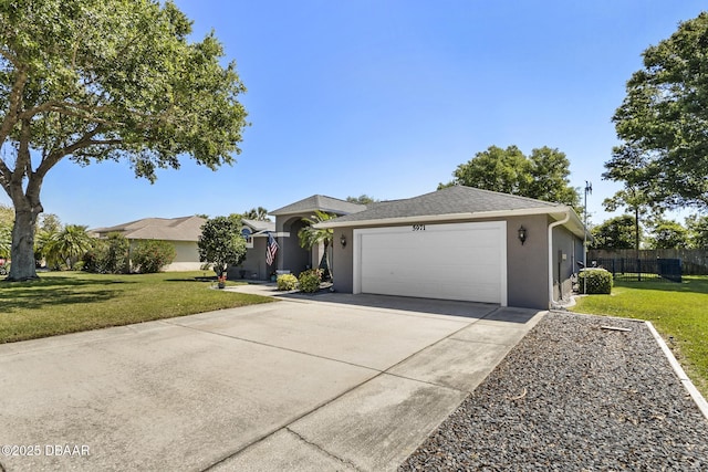 single story home with an attached garage, concrete driveway, stucco siding, and a front lawn