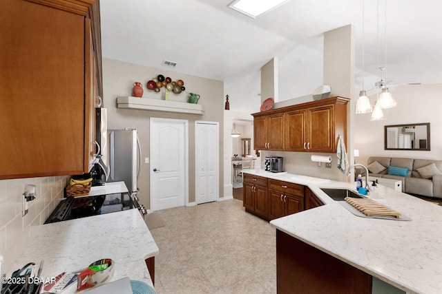 kitchen featuring a peninsula, visible vents, a sink, black range with electric stovetop, and backsplash