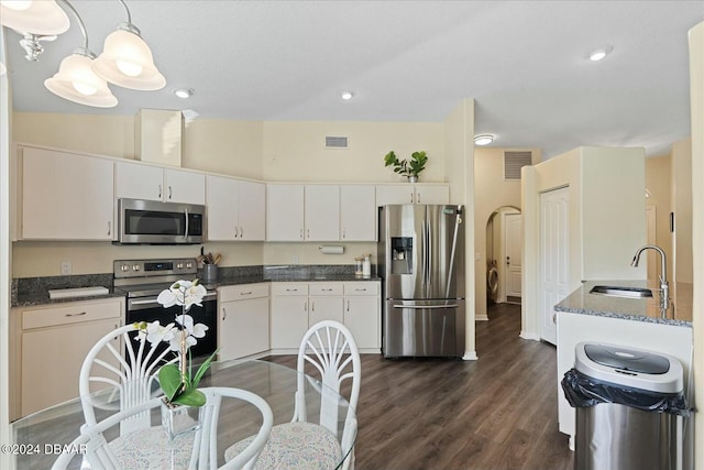 kitchen with white cabinetry, hanging light fixtures, appliances with stainless steel finishes, and dark wood-type flooring