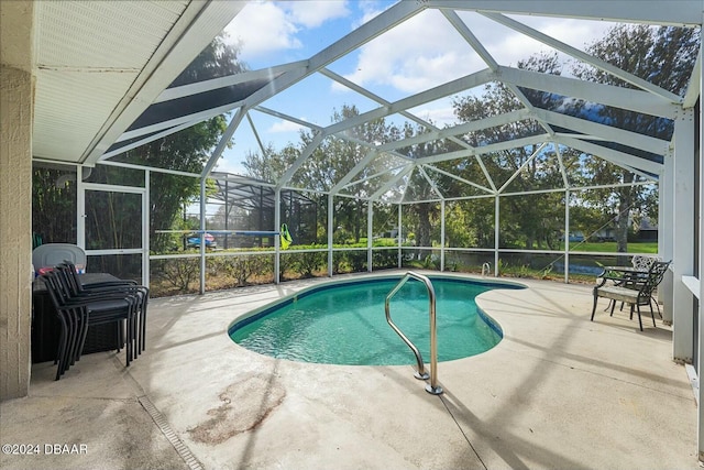 view of swimming pool featuring glass enclosure and a patio