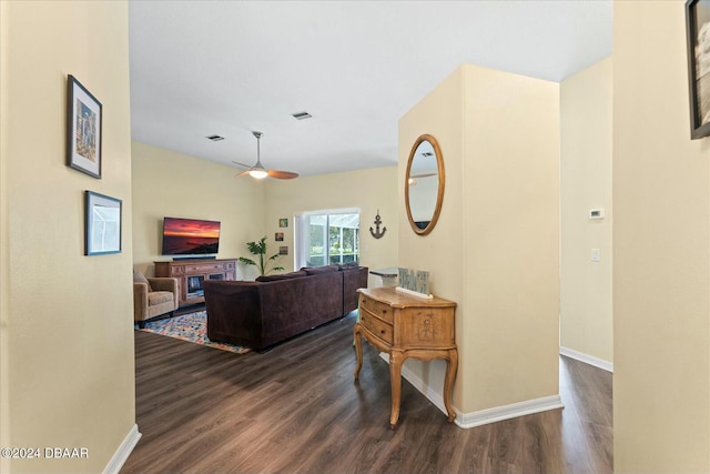 living room with ceiling fan and dark wood-type flooring