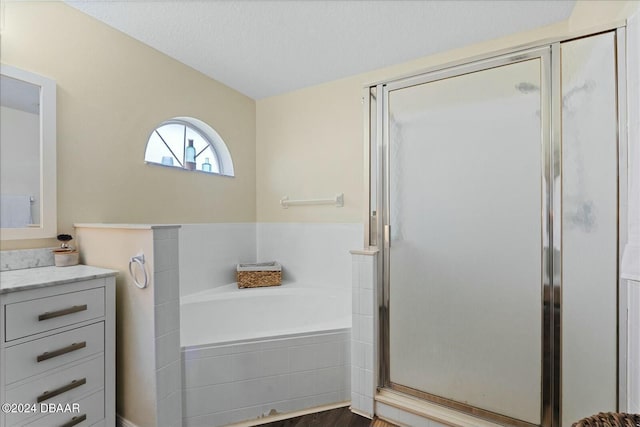 bathroom featuring vanity, wood-type flooring, a textured ceiling, and independent shower and bath