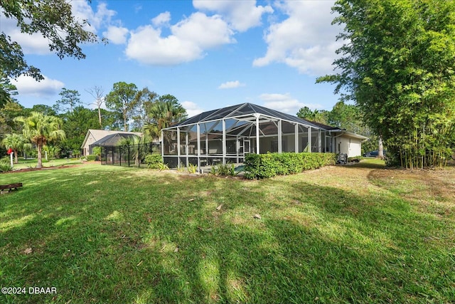 back of house with a lawn and glass enclosure