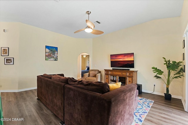 living room with ceiling fan, wood-type flooring, and vaulted ceiling