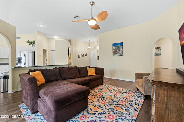 living room featuring ceiling fan and dark wood-type flooring