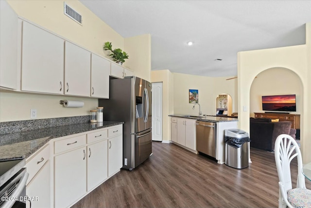 kitchen featuring white cabinetry, sink, dark hardwood / wood-style flooring, dark stone countertops, and appliances with stainless steel finishes