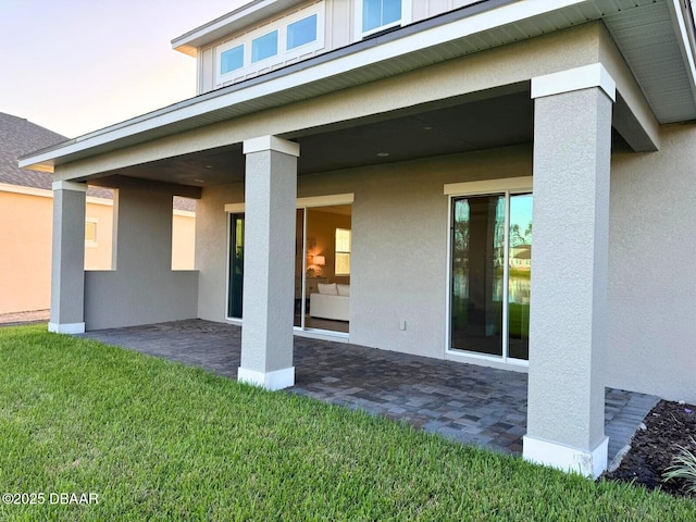 rear view of house with a patio and a lawn