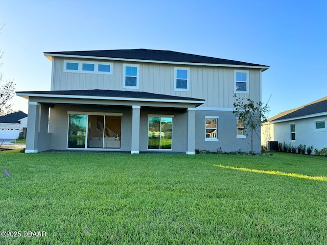 back of house featuring a lawn and central air condition unit