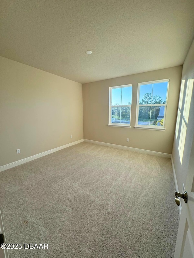 carpeted spare room featuring a textured ceiling