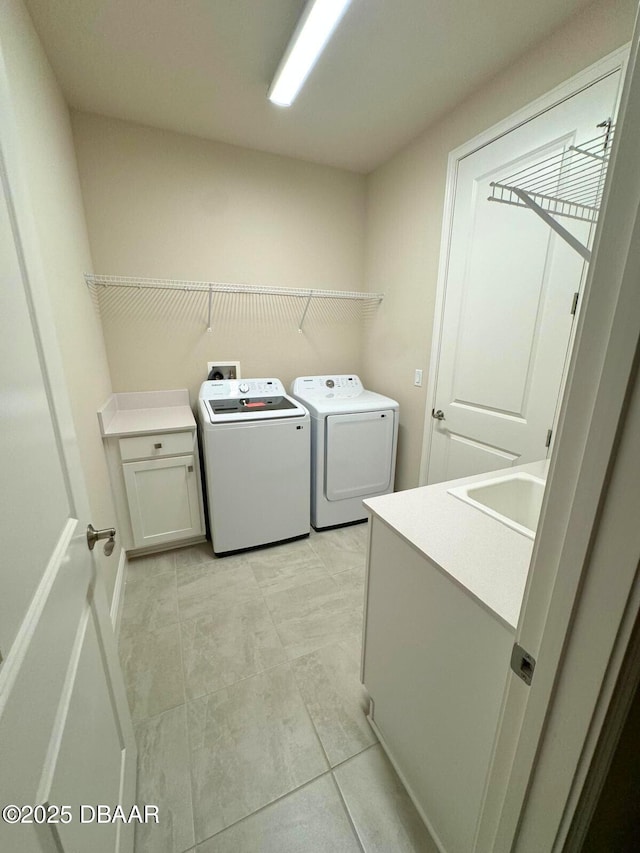 laundry room featuring cabinets, sink, and independent washer and dryer