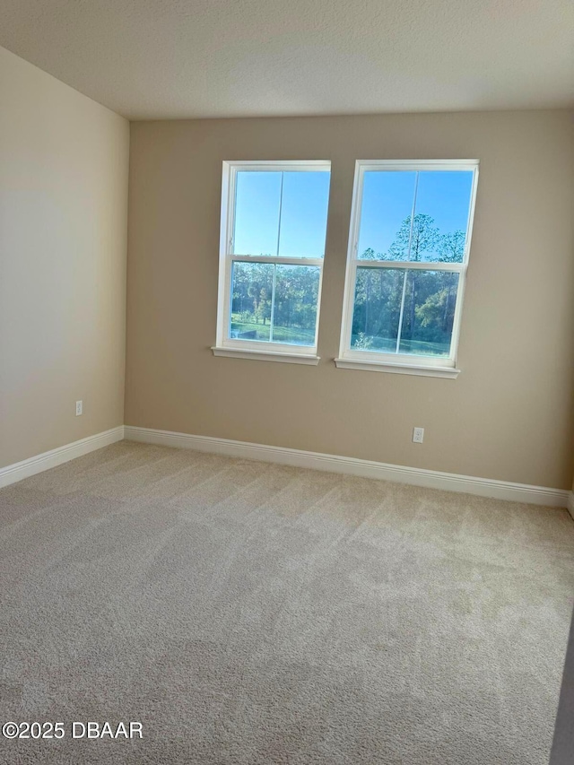 unfurnished room featuring carpet flooring and a textured ceiling