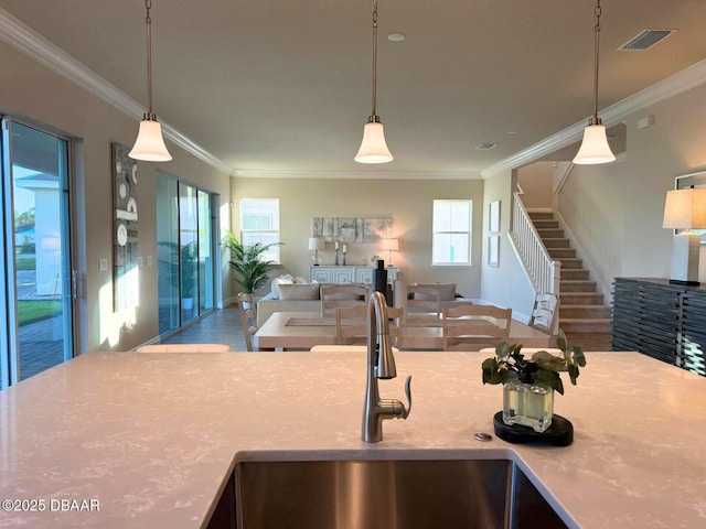 kitchen with crown molding, sink, and pendant lighting