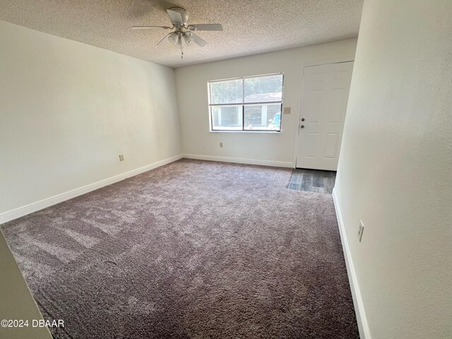 carpeted empty room featuring a textured ceiling and ceiling fan