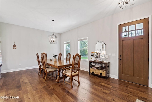 dining area with a wealth of natural light, a notable chandelier, and dark hardwood / wood-style flooring