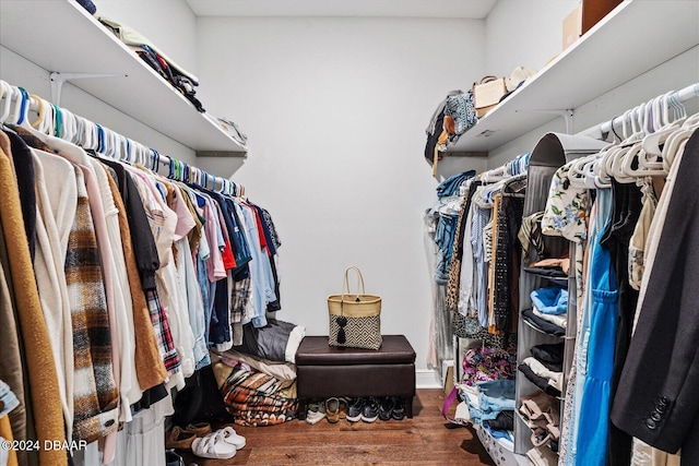 walk in closet with dark wood-type flooring