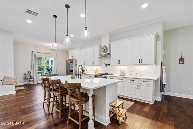 kitchen featuring an island with sink, dark hardwood / wood-style floors, white cabinetry, and gas stove