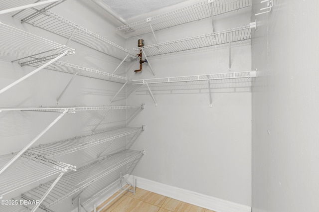 spacious closet with wood finished floors