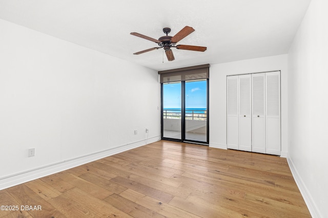 unfurnished bedroom featuring access to exterior, light wood-style flooring, baseboards, and ceiling fan